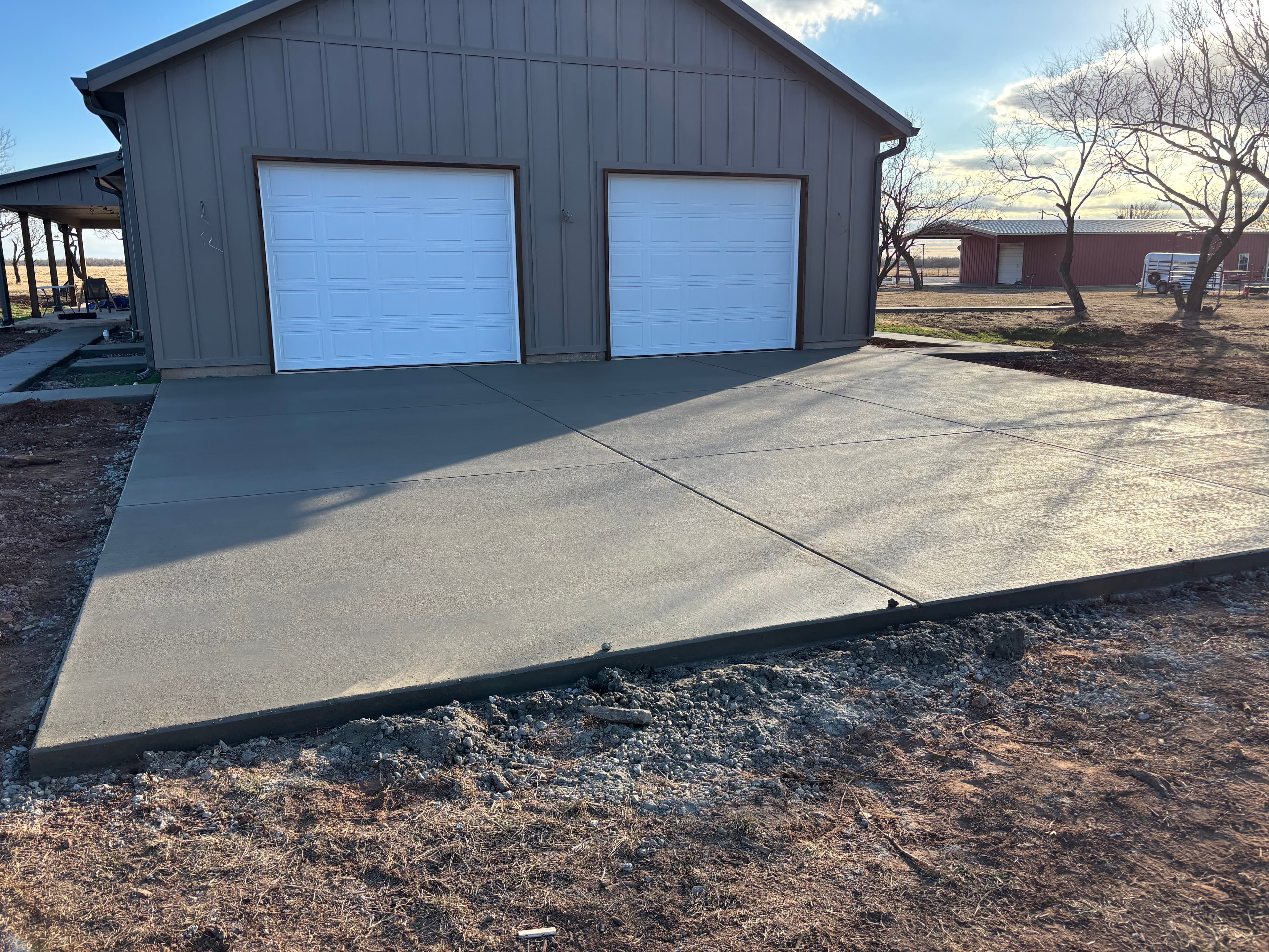 Finished concrete driveway apron in front of a barn shop in North Texas