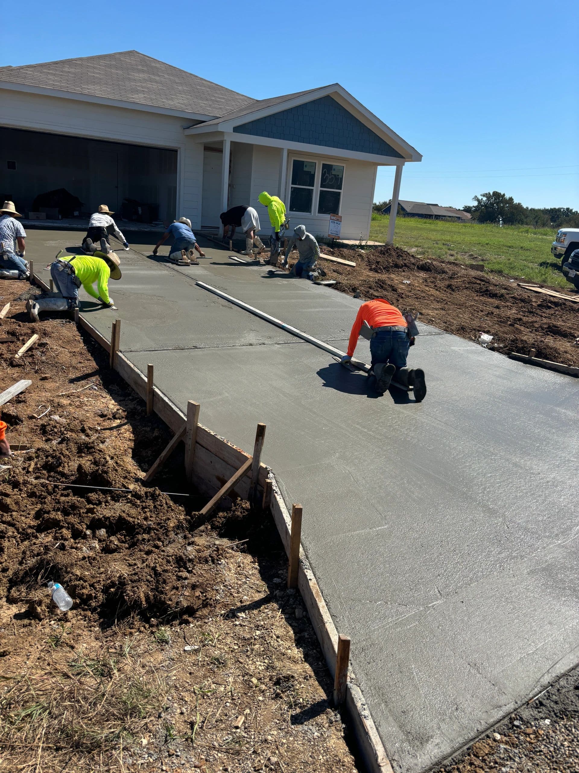 Full crew finishing a residential concrete driveway pour