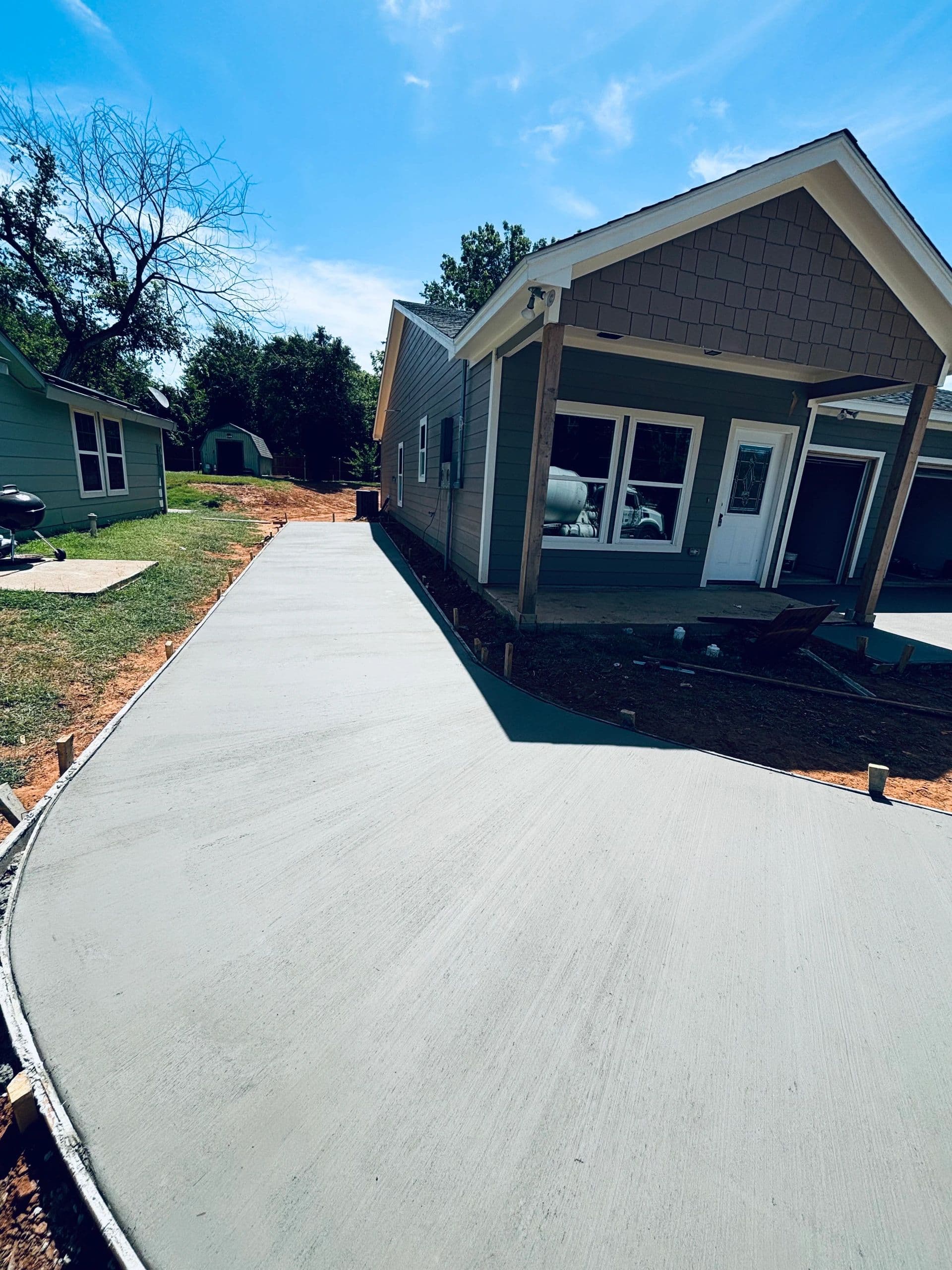 Long smooth concrete driveway pour beside new home