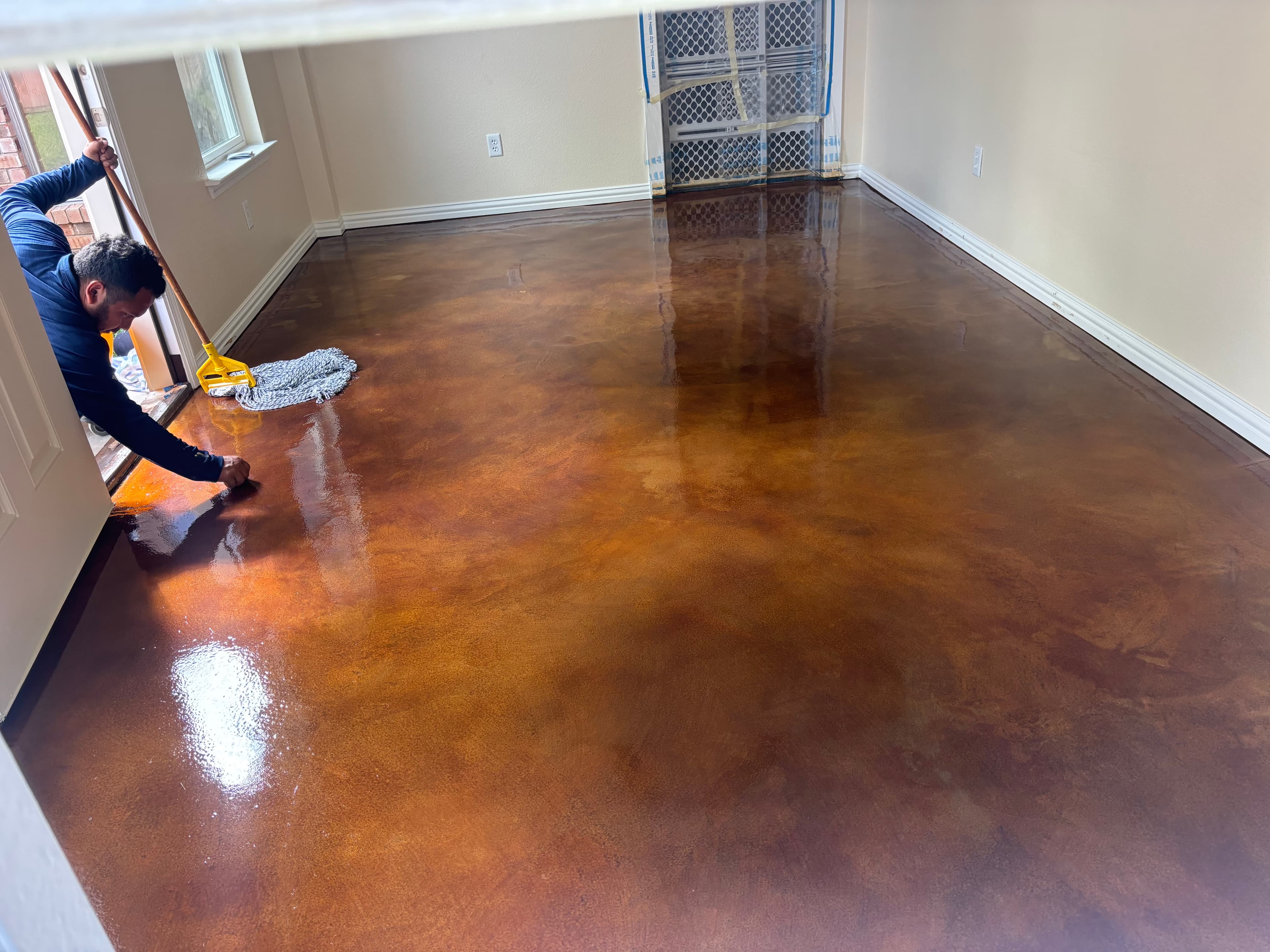 Acid stain being applied to interior concrete floor in North Texas