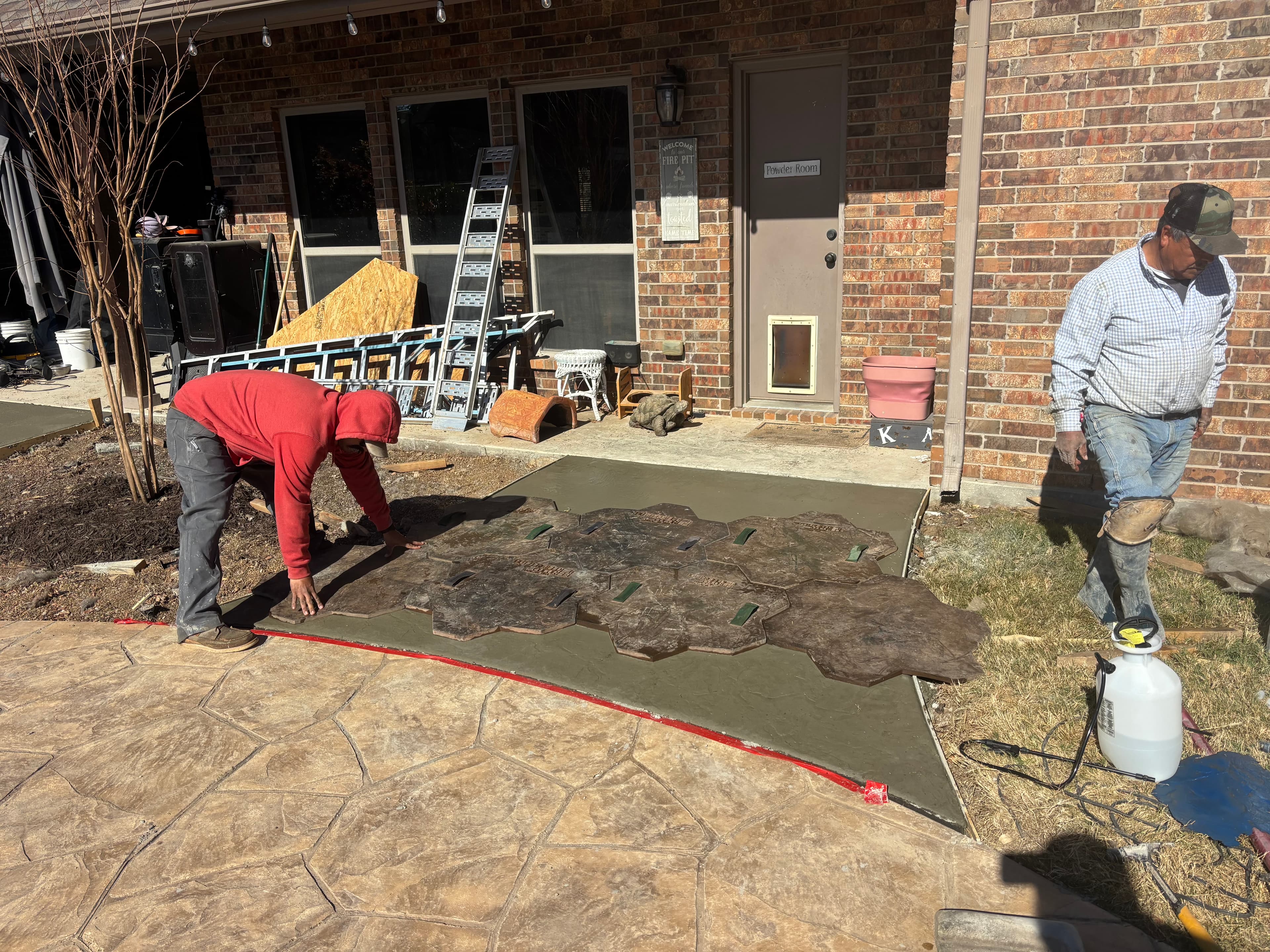 Crew applying stamp pattern to concrete patio in North Texas
